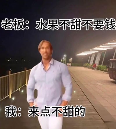 图片中美国健身网红迈克·奥赫恩（大力王梗主角）身着浅蓝色衬衫和白色裤子，双手插兜站在夜晚的人行道上，背景有灯光照明的长廊和栏杆。图片上方文字为“老板：水果不甜不要钱”，下方文字为“我：来点不甜的”，通过无逻辑对话形成“大力王文学”式的讽刺幽默，展现盲目自信情境下的搞笑互动。