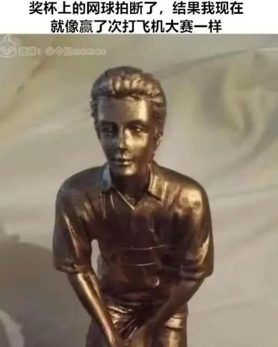 图片展示了一个青铜材质的人物奖杯雕像，雕像中的男子穿着短袖衬衫，面带微笑，双手在身前做出握持物品的姿势。原本应该在他手中的网球拍已经缺失，只剩下握持的动作。图片上方配有文字：'奖杯上的网球拍断了，结果我现在就像赢了次打飞机大赛一样'。

图片通过视觉双关制造幽默效果：当奖杯上的网球拍丢失后，人物双手握持的姿势看起来非常不雅，产生了类似自慰的联想，形成了滑稽的误解。