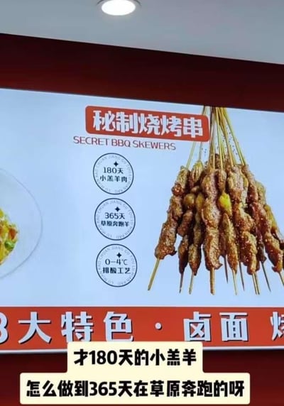 图片展示了一个烧烤店的宣传招牌，主打“秘制烧烤串”，招牌上印有烤串图片，并标注了三大卖点：“180天小羔羊肉”“365天草原奔跑”“0-4℃排酸工艺”。图片下方有叠加文字“才180天的小羔羊 怎么做到365天在草原奔跑的呀”，直指宣传语中的逻辑矛盾——180天的羔羊不可能拥有365天的草原奔跑时间，形成对商家夸大宣传的反讽。