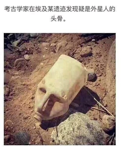 这是一张玩视觉错位梗的搞笑图，上方配文“考古学家在埃及某遗迹发现疑是外星人的头骨”，但图中所谓的“外星人头骨”其实是一个被半埋在泥土里的塑料水壶，因拍摄角度与泥土遮挡，水壶造型酷似带有凹陷眼部的怪异头骨，制造出虚假考古发现的荒诞反差笑点。