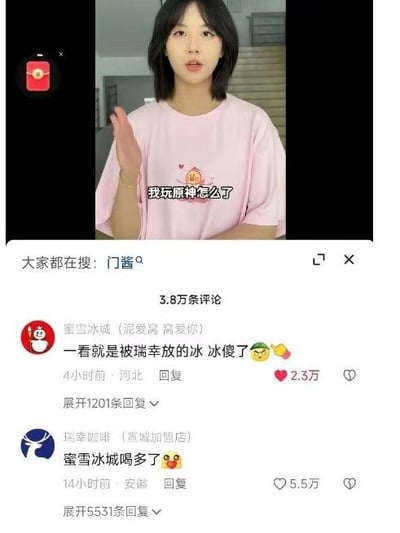 这是一张抖音平台的视频截图，画面主体是一位穿着粉色T恤的女生，画面配文为“我玩原神怎么了”。下方是该视频的评论区，蜜雪冰城官方账号评论“一看就是被瑞幸放的冰 冰傻了😜”，获得2.3万点赞；瑞幸咖啡（宣城加盟店）账号回复“蜜雪冰城喝多了🥴”，获得5.5万点赞。两条评论是茶饮品牌间的趣味互怼，结合女生的原神相关发言，制造出轻松搞笑的氛围，属于品牌的趣味互动营销内容。页面顶部显示“大家都在搜: 门酱”，说明该视频关联了相关热门搜索词。