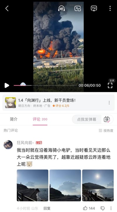 这是一张B站视频播放界面的竖版截图，正在播放的视频内容为一处工厂区域发生火灾，现场有大量橙红色火焰燃烧，浓黑的烟雾冲天而起高度可观。视频下方有《明日方舟：终末地》1.4版本上线的推广广告，再往下是评论区的热门首条评论，山东用户“狂风向前-”留言称自己当时沿海边骑小电驴，远远看到天边的黑烟误以为是造型好看的云觉得非常美，越靠近才疑惑为什么“云”连接在地面上，还附带了3张当时从远到近拍摄的照片，照片里远处的黑烟看起来和云朵十分相似，该评论发布于4小时前，获赞144次。