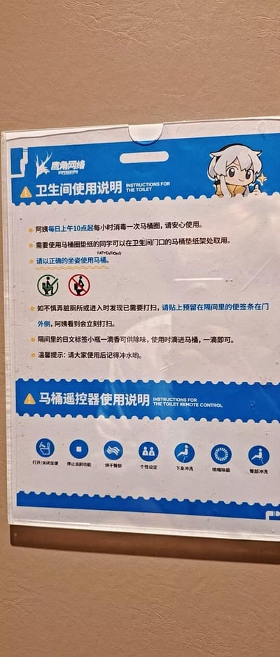 这是一张实拍的鹰角网络公司内部卫生间指引标识，整体为竖版图文混排样式，分为上下两个区域：上半部分是卫生间使用规范说明，包含马桶圈消毒频率、马桶垫纸取用方式、正确坐姿提示（配有正误坐姿的图示）、脏污处理方式、除味剂使用方法以及冲水温馨提示；下半部分是智能马桶遥控器的功能按键说明，标注了每个按键对应的功能。标识左上角有鹰角网络的品牌标识，右上角配有游戏《明日方舟》中的角色白面鸮的卡通形象，风格贴合公司的游戏IP属性，内容均为规范员工卫生间使用行为、维持办公区域卫生的实用指引。