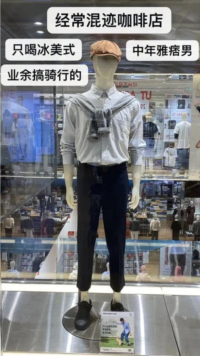 这张图是在优衣库（Uniqlo）店铺橱窗拍摄的人体模特展示，模特穿搭被配上了网络流行语标签，内容调侃中年男性时尚潮流：经常混迹咖啡店、只喝冰美式、中年雅痞男、业余搞骑行的。整体以幽默的口吻讽刺、定义都市中年男性的生活方式和穿搭审美，典型的都市“精致男士”模板，大有反差与自嘲意味。

这类梗图常用来调侃日常生活中那些“自认为很有品味/精致生活”的族群，让人产生共鸣和轻松一笑。

没有明显的双关或谐音梗，更多是对标签化生活方式的幽默总结。