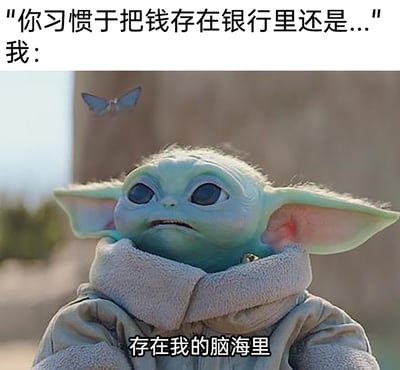 这是一张用于自嘲的搞笑表情包，采用图文混排的形式。上方是提问文字“你习惯于把钱存在银行里还是...”，下方是美剧《曼达洛人》里的角色格洛古（尤达宝宝）的影视截图，它眼神放空、表情怅然窘迫，配文“存在我的脑海里”，以幽默的方式调侃自己没有实际存款，只能在脑海里想象有钱的状态，精准戳中月光族、无积蓄人群的共鸣，十分接地气。