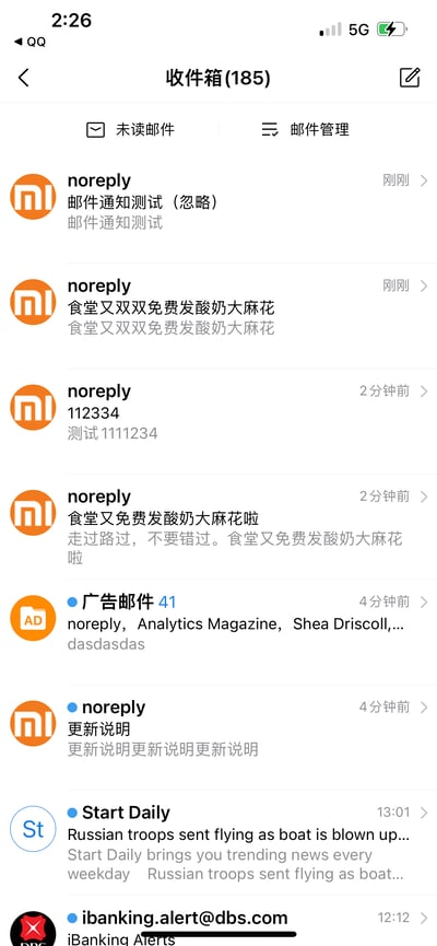 这是一张竖屏手机的QQ邮箱收件箱界面截图，收件箱总计有185封邮件，展示了最新收到的多封邮件内容。其中带有小米logo的noreply发件人发送了多封邮件，内容涵盖邮件通知测试、食堂免费发放酸奶大麻花的通知、数字测试邮件、更新说明等；同时还包含广告邮件、国外新闻媒体Start Daily的新闻邮件，以及星展银行的网银通知邮件，整体呈现了日常邮箱收到各类官方通知、测试邮件的场景。