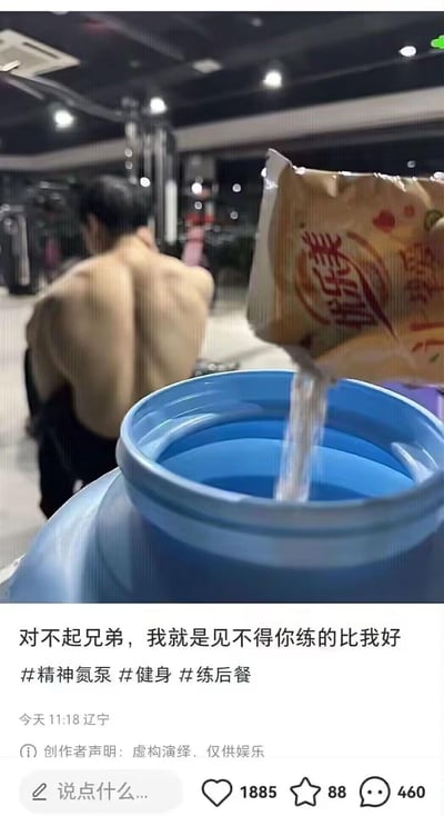 健身房场景中，一名赤裸上身的肌肉男正在休息，而镜头前有人正将一袋'优乐美'牌的粉末倒入一个蓝色大水桶中。图片下方配有文字：'对不起兄弟，我就是见不得你练的比我好'，暗示这是一个恶作剧，想通过往蛋白粉里加料来阻碍对方健身效果。