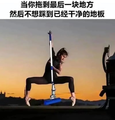 图片上方配有文字“当你拖剩最后一块地方然后不想踩到已经干净的地板”，下方是一位穿着黑色紧身衣、脚踩芭蕾舞鞋的女性，以高难度的芭蕾劈叉姿势，手持蓝色拖把在拖地。背景是橙黄色的日落天空，远处有模糊的城市轮廓。通过将优雅的芭蕾动作与日常拖地的场景结合，夸张地表现出人们在拖地时为避免踩到干净区域而做出的“高难度”姿势，形成幽默反差。