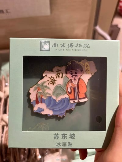 这是南京博物院推出的苏东坡主题文创冰箱贴，以Q版卡通化的苏东坡形象为核心，搭配海南地图轮廓、椰树、海浪山峦的场景元素，标注有“海南”字样与“东坡”标识，将苏东坡被贬海南的历史背景融入可爱的文创设计中，整体风格精致讨喜，适合作为纪念品收藏或用于冰箱装饰。