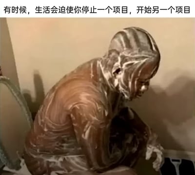 这是一张带有中文配文的海外整活视频截图，画面中一名真人全身被类似巧克力与奶油混合的粘稠物质完全覆盖，他蜷缩着蹲坐在地上，神情低落又无奈。图片顶部的配文“有时候，生活会迫使你停止一个项目，开始另一个项目”，用夸张荒诞的画面来比喻生活中原本的计划被意外状况打断，不得不被迫开启新的“混乱局面”，充满了自嘲与搞笑的意味，精准戳中人们面对生活突发变故、计划被打乱时的无奈心境。