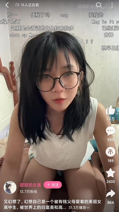 这是B站（bilibili）UP主「甜甜奶乐酱」的直播/视频截图，画面中博主戴着黑框眼镜，头发略显凌乱，身着无袖上衣，正面对镜头，似乎在和观众互动。屏幕上方是观众发送的实时弹幕，内容包含各种调侃、问候类话语，比如「便秘了吗」「祝早日康复」「这就是会讲话的白色拉布拉多」等；右侧是B站的视频互动栏，显示点赞1.2万、评论595、投币189、收藏2630、转发864；下方标注了博主拥有12.7万粉丝，视频标题为「又幻想了，幻想自己是一个被有钱父母爱着的美丽女高中生，被世界上的白富美和高...」，视频播放量达31.3万，背景是居家的卧室环境，整体氛围轻松随性。