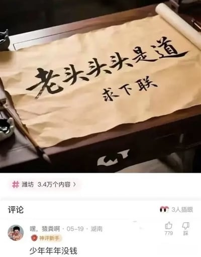 图片展示一张铺在木质桌面上的宣纸，上面用黑色毛笔字书写着“老头头头是道”，下方配有“求下联”字样，周围摆放着毛笔、砚台等书法工具。图片下方是社交媒体评论区截图，显示用户“嘿，猿粪啊”于05-19在湖南发布的热门评论“少年年年没钱”，获779个点赞。图中通过重复“头”字改编成语“头头是道”为“老头头头是道”制造幽默，评论则以“少年年年没钱”的叠字结构呼应，形成趣味互动。