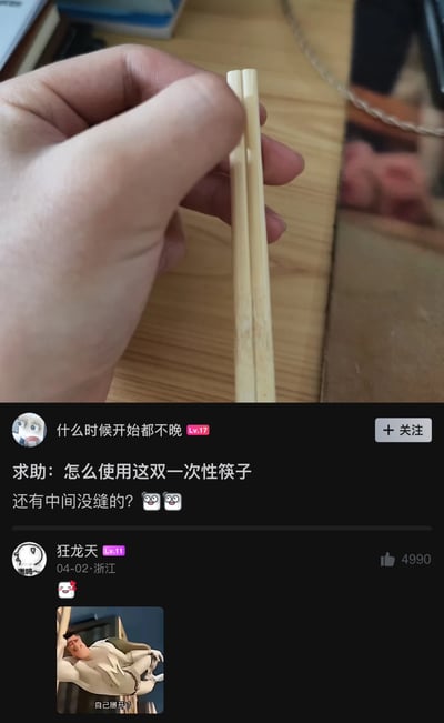 这是一张网络社区的发帖截图，图片上半部分展示了一只真人的手握着一根仍处于连体状态、未被掰开的一次性竹筷，筷子整体没有分开的缝隙；下半部分是帖子内容，ID为「什么时候开始都不晚」的楼主发帖求助，询问这双一次性筷子该如何使用，疑惑为什么筷子中间没有缝；下方是网友「狂龙天」的回复，回复搭配了一张错位肌肉男的网络梗图，梗图配文为「自己掰开？」，该回复获得了4990个赞。