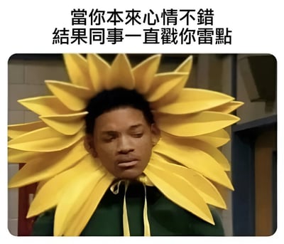 图片上方配有文字'當你本來心情不錯 結果同事一直戳你雷點'，下方是一位戴着巨大黄色向日葵头饰的男性，表情略显无奈和呆滞，整体呈现出原本心情良好却因同事不断触碰自己敏感点而变得低落的场景。
