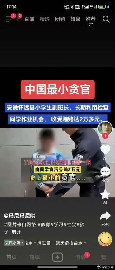 这是一张抖音平台的竖屏社交媒体截图，内容以调侃的方式呈现安徽怀远县一名11岁小学生副班长的事件：该学生利用检查同学作业的职权，长期向同学收受贿赂达2万多元，被配文戏称为“中国最小贪官”。图中使用了“小孩哥”“观干部”（谐音“班干部”）的网络热词玩梗，画面主体是被面部模糊处理的小学生和一名警察，小学生被警察控制，配文用夸张的表述将小学生的违规行为类比成贪官受贿，带有强烈的讽刺和调侃意味，旨在引发对教育、校园管理等社会话题的讨论，视频搭配的是搞笑滑稽风格的背景音乐。