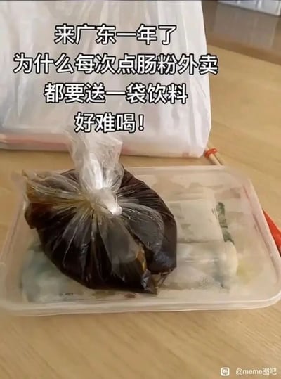 这是一张记录异地生活乌龙趣事的搞笑梗图。画面主体是一份广东肠粉外卖，肠粉放在透明餐盒中，上面用塑料袋封装着一袋深色的肠粉酱汁。图中上方配有文字：“来广东一年了，为什么每次点肠粉外卖都要送一袋饮料，好难喝！”，显然是一位刚到广东生活的外地人，不了解当地肠粉外卖的包装习惯，将用来浇淋在肠粉上的酱汁包误认成了商家赠送的饮料，还因为酱汁的味道不符合饮料的口感而吐槽，制造出了充满地域饮食文化差异的搞笑场景，让人忍俊不禁。