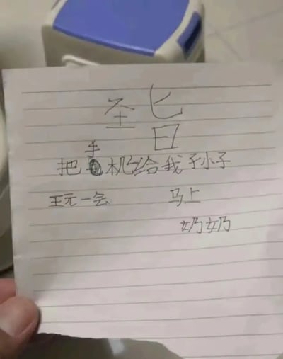 这张图片展示了一张手写纸条，内容看似是一个孙子的奶奶写下的纸条。纸条上写着“圣气七日，把手机给我孙子，玩一会，马上，奶奶”。纸条的表达直白且带有点童趣和幽默，让人很有画面感地联想到孙子特别想玩手机，于是奶奶出面“强硬发声”，像下达命令一样替孙子要回手机。整张图给人以轻松搞笑的氛围，具有生活气息和亲情的温暖。此外，“圣气七日”可能是“生气七天”的谐音或写错，带有一点小梗和儿童书写的幽默。

双关/谐音点：
- “圣气七日”可能为“生气七日”的趣味变写。