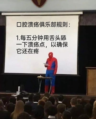 这是一张P图改编的搞笑梗图，画面中真人cos的蜘蛛侠站在讲台前，面对台下听众，身后的投影幕布上写着“口腔溃疡俱乐部规则：1.每五分钟用舌头舔一下溃疡点，以确保它还在疼”。图中用一本正经的正式演讲场景，搭配离谱又真实的规则文字，精准调侃了口腔溃疡患者忍不住反复舔舐溃疡、确认疼痛的自嘲式行为，戳中了有过口腔溃疡经历的人的共鸣点，充满了幽默的自嘲感。