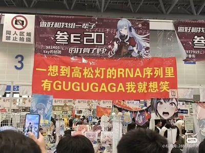 这是一张国内大型同人漫展的现场实拍图，场景位于同人展区（上方有“同人区域禁止拍摄”的标识），核心视觉是悬挂的红色醒目横幅，上面写着“一想到高松灯的RNA序列里有GUGUGAGA我就想笑”，玩了二次元企划《BanG Dream! It's MyGO!!!!!》角色高松灯的谐音梗——GUGUGAGA对应中文“咕咕嘎嘎”的拟声词，用生物学概念结合拟声词制造荒诞搞笑的整活效果。横幅上方是《BanG Dream! It's MyGO!!!!!》的社团宣传海报，写着“做好和我组一辈子的打算了吗？”，展区内还有多个同人摊位，摆放着各类角色立牌、同人作品，现场人头攒动，氛围热闹，充满二次元同好的欢乐气息。