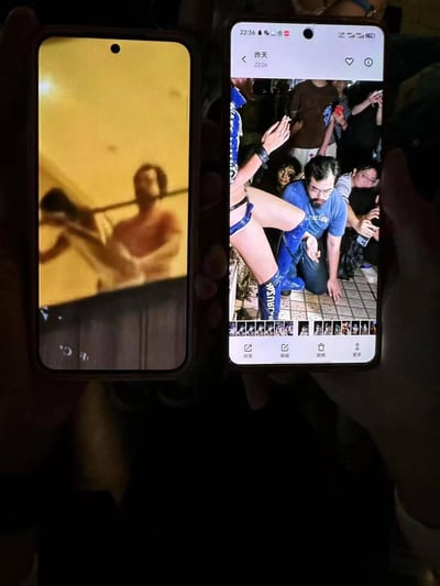 图片展示了两只手分别拿着两部智能手机，屏幕上显示着截然不同的场景。左侧手机屏幕显示一个黄色背景的室内场景，有两个人影，似乎在进行健身或某种体能训练，画面较为模糊。右侧手机屏幕显示一个社交媒体帖子界面，内容是一张现场照片，一名穿着蓝色服装和长靴的表演者正在表演，周围有许多观众在拍照围观，界面显示时间为22:36。两张手机屏幕形成鲜明对比，一边是私人健身场景，一边是热闹的公共表演现场。