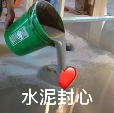 图片中一只手正提着绿色水泥桶，将灰色的水泥倾倒在地面上，水泥流动的轨迹末端被P上了一个鲜红的爱心图案，下方配有白色文字“水泥封心”。这张图通过视觉隐喻，将“用水泥封住心脏”这一抽象概念具象化，通常用于表达人们在经历情感挫折后，选择封闭内心、不再轻易付出感情的状态，带有自嘲和自我保护的意味。