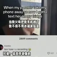 这是一张海外社交媒体的截图，主帖内容为英文搭配中文翻译：“When my parents take my phone away so now I gotta text her on my fridge 当我父母把我手机收了 我不得不用冰箱发信息”，描述了自己手机被父母没收后，用冰箱来发信息的离谱场景。下方的中文评论“兄弟，你是咋录像的”精准戳破了主帖的矛盾点——既然手机已经被没收，却能拍摄这个场景，形成了搞笑的反差感，让整个帖子的离谱程度升级，引发笑点。