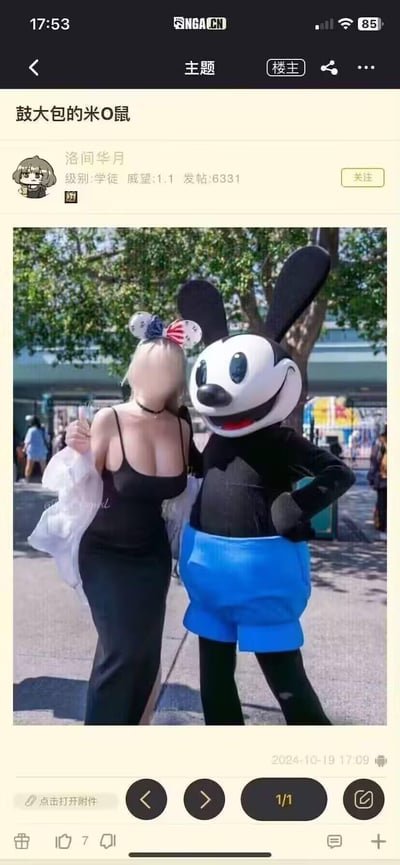 这是一张经过修图恶搞的迪士尼乐园合影图，一位穿着黑色吊带裙的金发女游客和奥斯华幸运兔人偶站在一起合影，奥斯华的蓝色短裤区域被P出了鼓起的大包，网友用“米O鼠”的谐音称呼它，结合“鼓大包”的双关含义制造出低俗搞笑的玩笑效果。