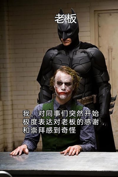 这张梗图选用《蝙蝠侠：黑暗骑士》里蝙蝠侠审讯小丑的经典影视场景进行二次创作，将画面里的蝙蝠侠标注为职场中的“老板”，坐在前方的小丑则代表职场里的普通员工。配文以员工的视角，表达了对身边同事突然毫无征兆地极度吹捧、崇拜老板的行为感到困惑不解的心情，精准还原了职场中不少人面对同事刻意讨好上级时的迷惑心态，用经典影视画面结合职场日常，容易引发职场人群的共鸣。