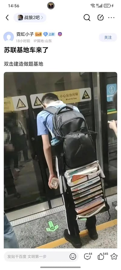 这是一张发布在百度贴吧的玩梗帖子，主体内容是地铁站台的真实照片：一名学生站在地铁车门旁，背着的超大书包下方挂着厚厚一摞书本，沉重的课业负担让他的背影酷似游戏《红色警戒》里的苏联基地车。帖子配文“苏联基地车来了”“双击建造做题基地”，将学生需要时刻投入做题学习的状态，类比成基地车展开建造基地的设定，用游戏梗调侃学生沉重的课业压力，充满搞笑与无奈的氛围。