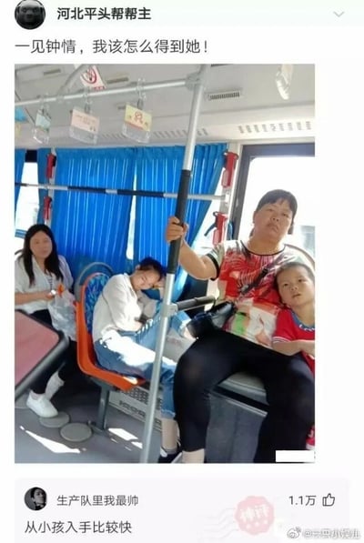 这是一张来自微博的搞笑社交动态截图。顶部是用户“河北平头帮帮主”发布的内容，配文“一见钟情，我该怎么得到她！”，并附带一张公交车内的实拍照片，照片里一位年轻女性靠在座椅上熟睡，从视觉角度看，她和旁边被中年女性抱着的小孩似乎有亲子关联，这位年轻女性应该就是发布者心仪的对象。下方是用户“生产队里我最帅”的评论“从小孩入手比较快”，该评论利用照片的视觉错觉，调侃发布者可以通过小孩来接近心仪女性，这条评论获得了1.1万点赞，还被标注“神评”，整体内容充满趣味，是网友之间的搞笑互动。