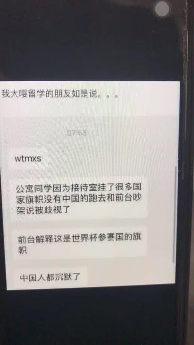 手机屏幕截图展示了一段聊天记录，内容讲述一名留学生在国外公寓因接待室未悬挂中国国旗而与前台发生争执，认为受到歧视。前台解释称所挂旗帜均为世界杯参赛国国旗，这一回应让在场中国人陷入沉默，形成尴尬又略带无奈的场景。其中“大嘤”为网络对“英国”的戏称。