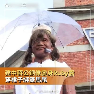 台北建国中学的蒋公铜像被人进行了恶搞改装：给铜像扎了双马尾，穿上白色带花边的女装上衣，头顶安装了透明雨伞，脸部还贴了类似麦克风的装饰，将原本严肃的历史人物铜像改造成了名为Ruby酱的搞笑女装形象，反差感拉满，画面十分滑稽。