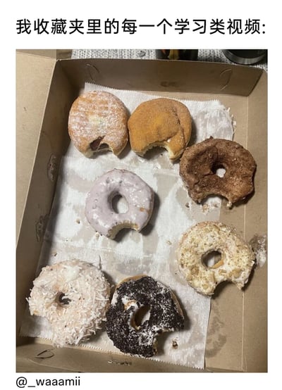 这是一张搞笑类梗图，图中展示了一盒每个都被咬了一口但未被吃完的甜甜圈，顶部配文“我收藏夹里的每一个学习类视频:”，用生活化的场景类比，生动调侃了很多人收藏学习类视频后，只是象征性地看了开头，并没有完整学习、深入观看的“伪学习”现状，容易引发有类似经历的人的共鸣。