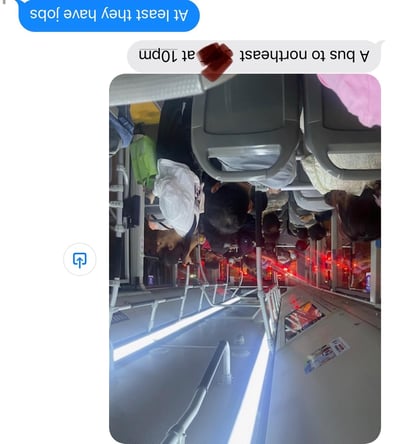 这是一张竖版的公交内部实拍图，拍摄于夜晚，画面中可见拥挤的乘客，有人坐着有人站着，整体氛围略显疲惫。图片上方添加了两个英文文字气泡，分别为“At least they have jobs”（至少他们有工作）和“A bus to northeast at 10pm”（晚上10点开往东北的公交车），文字内容似乎在调侃深夜仍在通勤的人们与工作的关系。