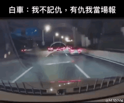 这是一段源自行车记录仪的动态GIF图，呈现了夜晚道路上的驾驶场景。画面上方配有文字“白車：我不記仇，有仇我當場報”，结合画面内容，调侃白车在驾驶过程中做出了当场“反击”的操作，用网络流行梗赋予普通交通场景搞笑戏谑的氛围，让人会心一笑。