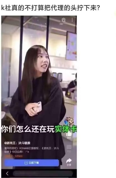这是一张吐槽《游戏王：决斗链接》国内代理公测广告的梗图，图中截取了广告里的女生画面，配文“你们怎么还在玩实体卡”，上方还有网友吐槽“k社真的不打算把代理的头拧下来？”。该广告采用踩一捧一的方式，冒犯了游戏王实体卡玩家，而KONAMI本身也在运营实体卡业务，这种宣传方式相当于打了原作方的脸，因此被玩家制作梗图调侃，引发游戏圈的讨论。