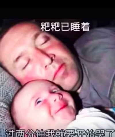 图片中展示了一位爸爸闭着眼睛安详地睡着，脸颊微红，头靠在枕头上。他身旁依偎着一个醒着的宝宝，宝宝睁着眼睛，嘴角微微上扬，表情略带狡黠。图片上方有文字“粑粑已睡着”，下方文字“过两分钟我就要开始哭了”，通过宝宝的视角制造出幽默反差，展现了亲子间有趣的互动瞬间。