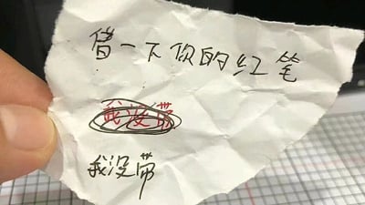 这是一张被人手拿着的皱巴巴的白色纸条，纸条上有三段手写文字：最上方是黑色字迹的‘借一下你的红笔’，是借笔者的诉求；中间是用红笔书写的‘我没带’，并且被黑色笔迹圈了起来；最下方又是黑色字迹的‘我没带’。整个内容形成了强烈的反差与矛盾：被借笔者回复自己没带红笔，却使用了红笔来书写这条回复，这种自相矛盾的情况制造出尴尬又好笑的效果，是生活中不经意间出现的趣味小瞬间，大概率发生在校园或者职场的同事、同学之间。