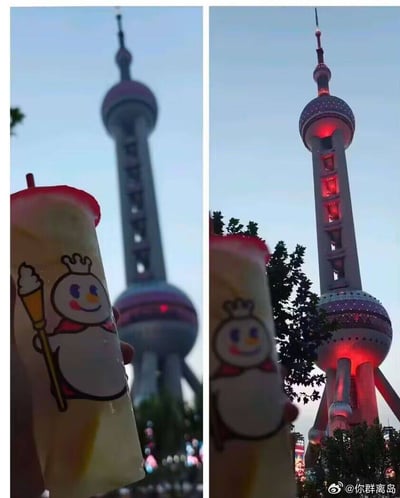 这是一组左右对比的错位摄影图，左图中，前景的蜜雪冰城雪王奶茶杯，利用近大远小的透视原理，让雪王手持的冰淇淋火炬图案与背景中的上海东方明珠塔下球完美重合，营造出雪王“举着”东方明珠的搞笑视觉效果；右图调整了拍摄角度，错位效果消失，还原了奶茶杯与东方明珠塔的真实位置关系，此时东方明珠塔亮起了红色灯光，周围的树木和人群也清晰可见。
该图无任何双关、谐音梗或暗示内容，纯粹是利用摄影角度制造的趣味视觉错觉。