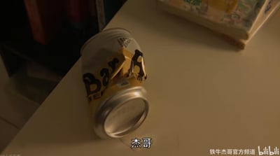 画面中展示了一个皱巴巴的银色和黄色易拉罐，罐身上可见部分“Bar”字样，倒放在浅色桌面上。背景隐约有书架和书籍，图片底部有白色字幕“杰哥”，右下角有水印“铁牛杰哥官方频道 bilibili”。整体场景像是某个视频中的片段截图，带有幽默或调侃的意味，与“杰哥”相关梗文化有关。