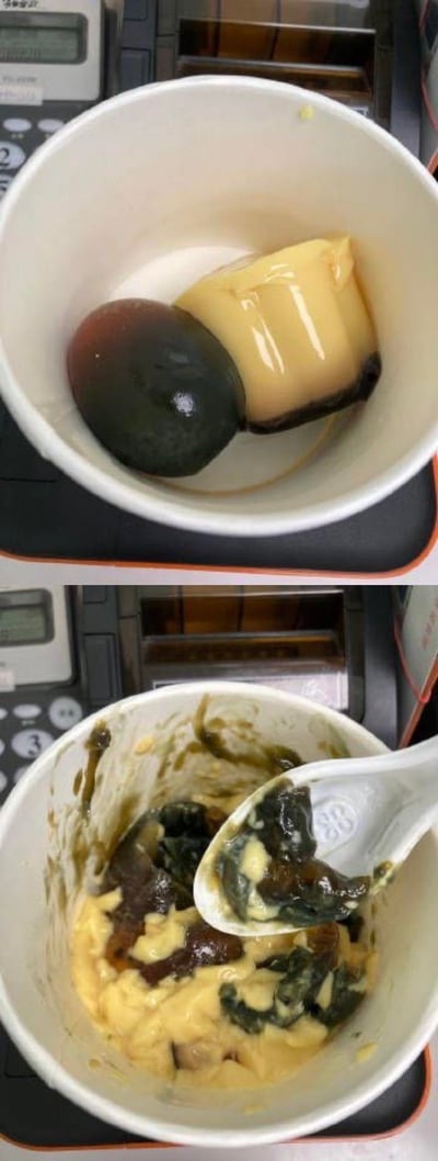 这是一组上下对比图，上图展示白色纸碗中放置着一颗完整的皮蛋和一块布丁，两种风格完全迥异的食物被放在一起；下图则是将两者混合搅拌后的状态，碗内和勺子上都是皮蛋与布丁交融后的糊状深色物质，呈现出极具冲击力的黑暗料理视觉效果，打破常规食物搭配逻辑，充满猎奇感。