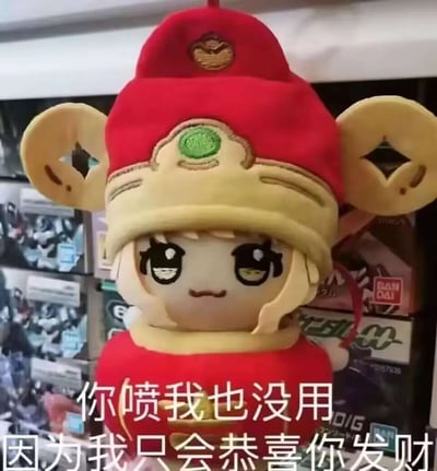 图中是身着财神主题红金服饰的木之本樱棉花娃娃，玩偶有着圆溜溜的大眼睛，表情带点小得意又满是无所谓。下方配文“你喷我也没用 因为我只会恭喜你发财”，用可爱的喜庆形象搭配摆烂式的讨喜语气，既能幽默回怼恶意吐槽的人，也能在春节等喜庆场合传递祝福，以轻松的方式化解负面情绪，营造欢乐氛围。