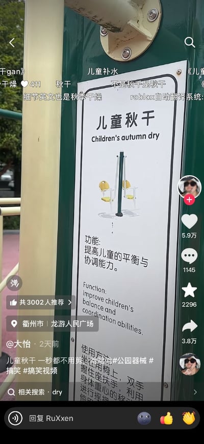 这是一张竖版抖音短视频截图，画面主体是公园健身器材上的白色说明牌。标牌中文标题为“儿童秋千”，但下方英文却写成“Children's autumn dry”，形成明显的机翻或 OCR 识别错误。标牌上的功能说明部分翻译正常，写着“提高儿童的平衡与协调能力”以及“Improve children's balance and coordination abilities.”，更凸显标题翻译的荒谬。画面上叠加了多条观众评论，例如“不是秋千是秋干”“细节英文也是秋季干燥”“roblox自动翻译系统”等，集中吐槽把“秋千”错误拆译成“秋天干燥”。视频文案称“一秒都不用剪”，定位显示为浙江省衢州市龙游人民广场，发布者为@大怡。界面右侧显示点赞5.9万、评论1145、收藏2296、转发3.8万。