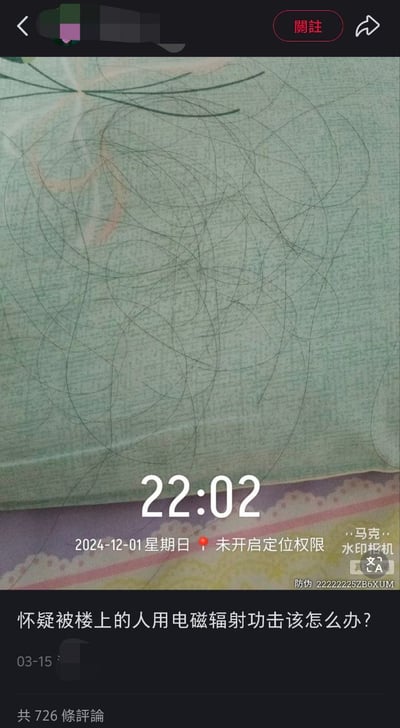 这张图片是社交媒体上的一张截图，背景是一张床单或枕头，上面有许多乱糟糟的长头发。图片中央显示22:02的时间和日期为2024年12月1日，似乎是截取于某短视频平台或社交App的页面。图片下方有网友留言提问：“怀疑被楼上的人用电磁辐射功击该怎么办？”，属于典型的网络迷惑发言，带有一定的荒诞和自嘲成分。在网络语境下，这类发言常被用来调侃生活中难以解释的“玄学”或“中招”现象，也包含了网友对“被迫害妄想症”式发言的玩梗嘲讽。双关及暗示：图片中大量头发可“梗”指发友脱发，和精神压力或脑补相关联。