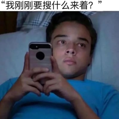 图片中一名男子躺在床上，穿着蓝色上衣，双手举着智能手机，表情困惑地望向手机屏幕。图片顶部配有文字“我刚刚要搜什么来着？”，生动表现了人们日常生活中突然忘记原本要搜索内容的健忘瞬间，具有强烈的共鸣感和幽默效果。