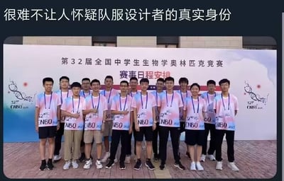 这是一张带有调侃性配文的真人合影照片。照片主体是第32届全国中学生生物学奥林匹克竞赛的参赛学生，他们身着粉蓝渐变的统一队服，站在印有“第32届全国中学生生物学奥林匹克竞赛 赛事日程安排”的背景板前整齐合影。合影人群里仅出现一位女生，其余均为男生，结合队服上的“32nd CNBO 2023”字样，顶部配文“很难不让人怀疑队服设计者的真实身份”，用谐音和性别比例的反差制造笑点，调侃生物竞赛中男女生比例失衡的现象，充满趣味和调侃意味。