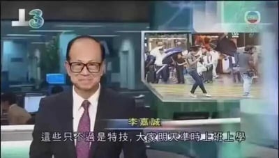 新闻演播室场景，一位男性新闻主播正在播报新闻。屏幕右侧有一个小窗口插播画面，显示多人在户外聚集的场景。主播下方字幕显示："这些只不过是特技，大家明天准时上班上学"。