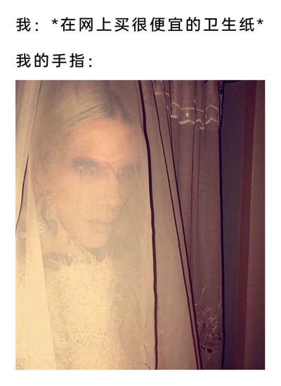 这是一张结合文字与图片的搞笑梗图，聚焦日常生活中网购廉价卫生纸的小尴尬。上方文字分为两部分，“我”的行为是网购廉价卫生纸，“我的手指”则对应下方的图片——一名真人躲在半透明窗帘后，露出半张脸，眼神诡异阴森、表情惊悚，营造出一种突然被“袭击”的恐怖氛围。该图用夸张的恐怖感来比喻廉价卫生纸因质地粗糙，极易划破手指的常见体验，将日常小倒霉转化为搞笑的反差感，引发网友对类似生活经历的共鸣。
