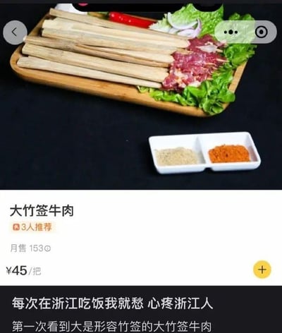 这是一张外卖平台的菜品展示截图，图中展示的是名为“大竹签牛肉”的菜品，售价45元一把，月售153份，有3人推荐。菜品呈现为多根巨大的竹签上仅串了少量牛肉，搭配生菜、红辣椒、洋葱作为配菜，旁边摆放着两小碟分别装着浅色和橙色的调味料。图片下方配有吐槽文字：“每次在浙江吃饭我就愁 心疼浙江人 第一次看到大是形容竹签的大竹签牛肉”，调侃这道菜名里的“大”并非形容牛肉，而是指竹签，吐槽该菜品肉量过少，反差感拉满，引发对浙江餐饮分量的调侃。