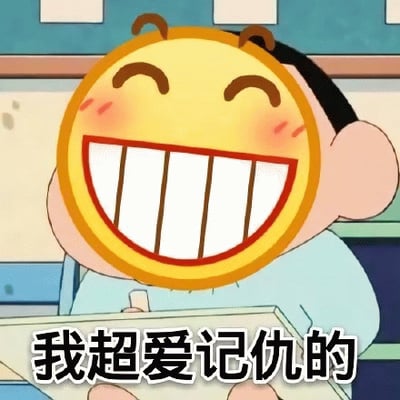 图片中是一个卡通角色，其头部被一个巨大的黄色笑脸表情（圆形，红色轮廓，咧嘴大笑，脸颊带有红晕）替代，角色身穿浅蓝色上衣，坐在书桌前手中拿着书本。背景疑似教室环境，有蓝色墙壁和白色方块装饰。图片底部配有文字“我超爱记仇的”，通过角色开心的表情与“记仇”这一带有负面含义的文字形成反差，营造出幽默搞笑的效果。